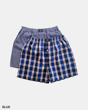 The Coast Clothing Woven Check Boxers 2 Pack is displayed against a plain white background, showcasing two pairs of blue plaid boxers. One pair, crafted from 100% cotton, features a smaller checkered pattern, while the other pair boasts a larger and more distinct plaid design. The word "BLUE" appears in the bottom-left corner of the image.