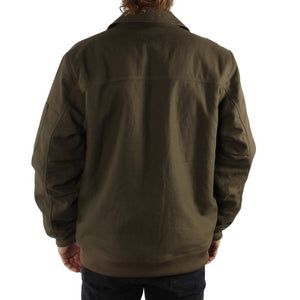 A person with long hair is seen from the back wearing a dark olive green Ringers Western Mildura Sherpa Bomber Jacket and black pants. This rugged, water-resistant jacket features sherpa lining and a collar, offering a loose fit that extends beyond the waistline. The background is plain white.