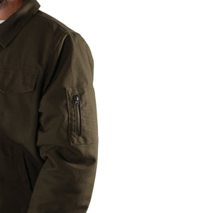 A person wearing the Ringers Western Mildura Sherpa Bomber Jacket in olive green, featuring durable water-resistant fabric and a zipper pocket on the left sleeve. The image is cropped to show only the upper torso and part of the left arm, emphasizing the jacket's sherpa lining and intricate details against a plain white background, showcasing Ringers Western quality.