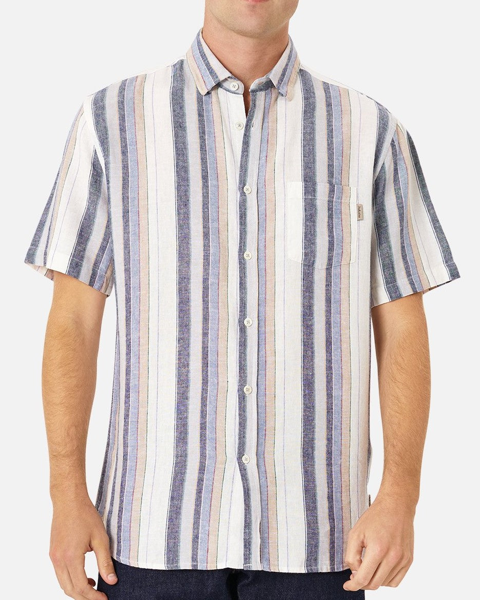 A person is wearing Industrie The Tobago Shirt, a short-sleeved, button-up lightweight shirt with vertical blue, white, pink, and yellow stripes. The shirt has a single chest pocket featuring the Industrie logo, and the person's hands are relaxed by their sides. The background is plain white.