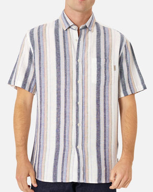 A person is wearing Industrie The Tobago Shirt, a short-sleeved, button-up lightweight shirt with vertical blue, white, pink, and yellow stripes. The shirt has a single chest pocket featuring the Industrie logo, and the person's hands are relaxed by their sides. The background is plain white.
