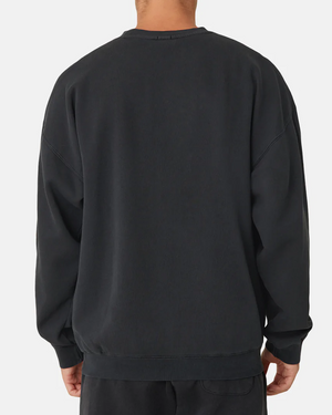 The person is wearing Industrie The Del Sur Sweat, a plain black, long-sleeved oversized jumper paired with matching pants, viewed from the back against a white background, exuding a relaxed and casual vibe.