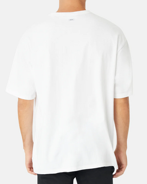 A person wearing the Industrie The Del Sur Tee, a loose-fitting oversized 100% cotton T-shirt with short sleeves, and black pants stands against a light gray background, facing away from the camera.