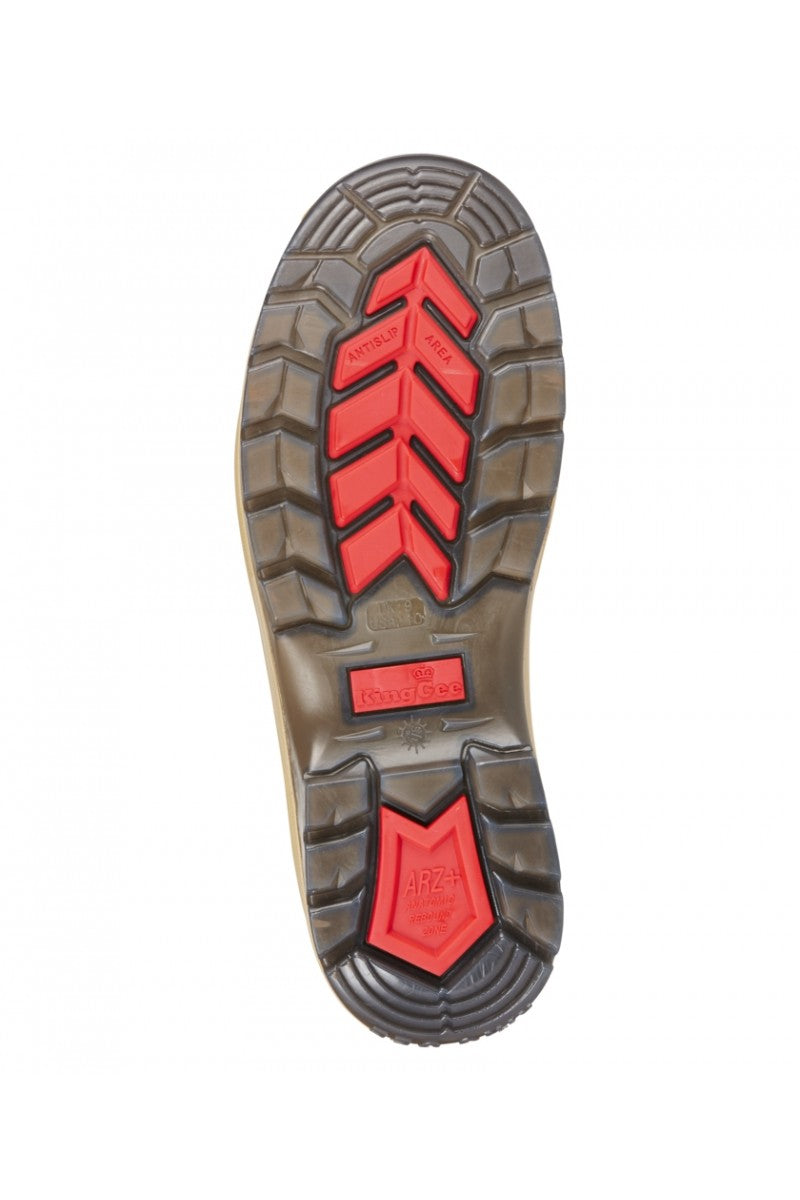 The image displays the sole of the King Gee Tradie Zip Safety Boot K27100, featuring a mix of black and red rubber treads, central and top text and logos, a zigzag geometric pattern, and a slip-resistant sole for optimal traction.