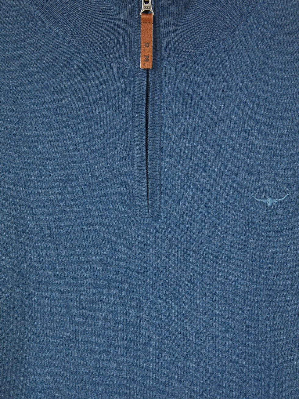Close-up of the RM Williams Ernest Sweater in blue wool, featuring a quarter-zip neck with a brown leather pull tab marked "P.M." and an embroidered horned longhorn logo on the left chest.