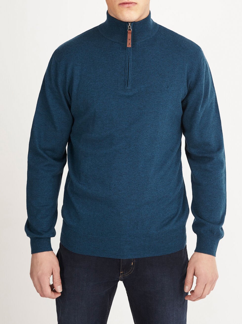A person wears the RM Williams Ernest Sweater, a teal wool quarter-zip, with dark jeans, standing facing forward against a plain white background.