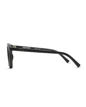 The Liive Manhattan Sunglasses feature a side view of black frames crafted from durable polycarbonate with straight arms. The inner arm displays "MANHATTAN" and markings in white text. With UV protection and a subtle nose bridge curve, they effortlessly blend style and functionality.