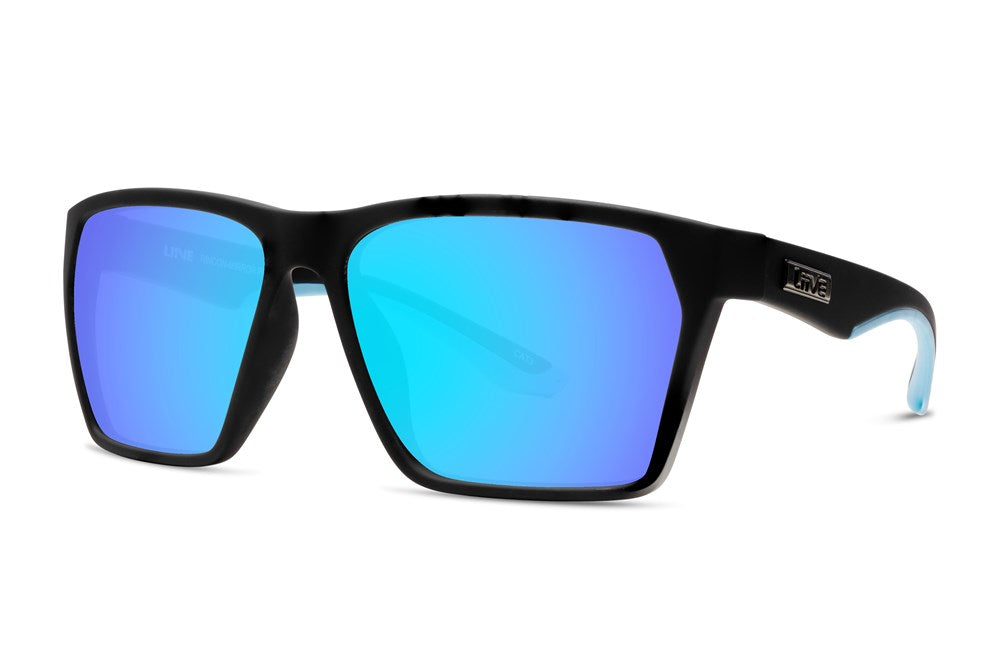The Liive Rincon Mirror Sunglasses feature a black frame and blue-lens mirrors against a white background. Made from lightweight polycarbonate, these sunglasses offer UV protection. A small logo on the temple arms complements the sleek, modern design.