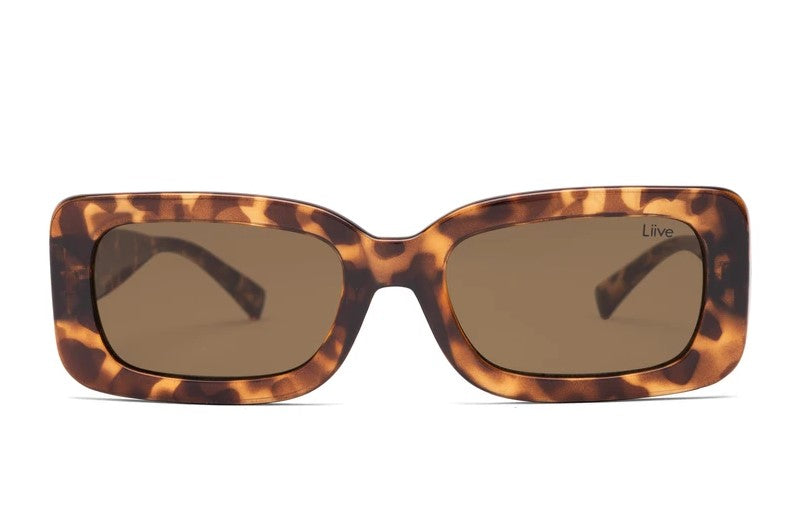 Introducing the Liive Crush Sunglasses: tortoiseshell rectangular frames with dark brown polycarbonate lenses for superior UV protection. The brand "Liive" is on the top right lens, and the frame features a classic speckled pattern in rich brown shades.