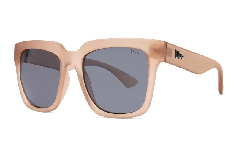 Introducing Liive Layla Sunglasses: These chic glasses feature a matte pink thick frame with dark rectangular, optically correct lenses that offer UV protection. A small logo graces the temple, adding an elegant touch.