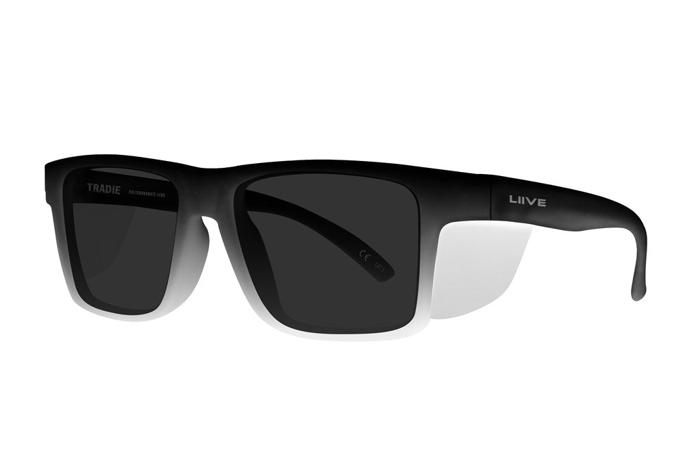 The Liive Z Tradie Safety Sunglasses have rectangular frames with black and white gradient shade, dark shatterproof lenses for UV protection, the "Liive" logo on one arm, and "Tradie" inside the other arm.