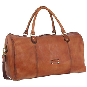 The Pierre Cardin Leather Overnight Bag is crafted from brown leather with brass hardware. It features two top handles, an adjustable shoulder strap, and a zippered top closure. The bag includes a rectangular metal plaque on the front and showcases a smooth finish with some natural variation, exemplifying Pierre Cardin's craftsmanship.