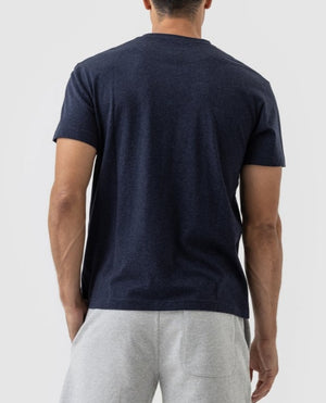 A man wearing a sports fit dark blue Rodd & Gunn The Gunn T-Shirt made of Australian Cotton and light gray shorts stands with his back to the camera against a plain background.