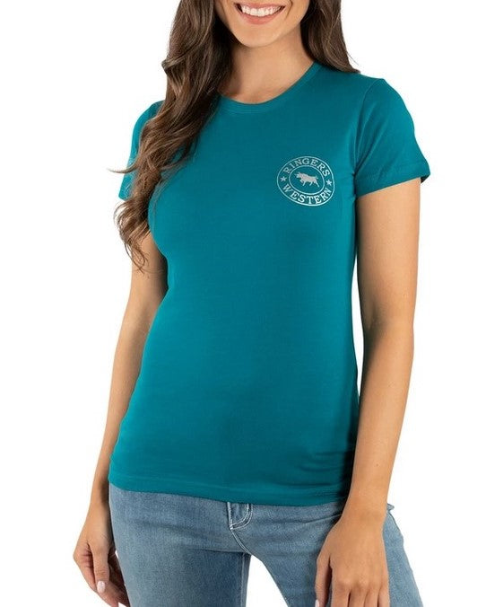 A woman wearing a Ringers Western Womens Signature Bull Classic Fitted T-Shirt made from 100% cotton in teal, featuring a circular logo on the chest that depicts a bear with the words "Wilderness Adventure." She has long brown hair and is accessorized with light blue jeans. The comfortable, casual T-shirt perfectly complements her smiling pose against a plain white background.
