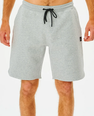 A person wears light gray Rip Curl Vaporcool Short with a black drawstring and small black logo on the left pocket. These comfortable knee-length shorts are against a plain white background.