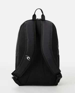 The Rip Curl Ozone 30L Icons Eco Backpack, crafted from recycled plastic, features a black design with padded shoulder straps and mesh back panel. A small logo embellishes one strap. It includes a secure laptop section for modern needs. The background is off-white.