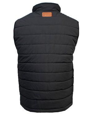 A black Ritemate Pilbara Reversible Vest with horizontal stitching is shown from the back. It features a high collar and a small brown leather patch at the top center, embossed with a logo and text. This comfortable vest appears to be quilted and padded for warmth, making it perfect for chilly days.