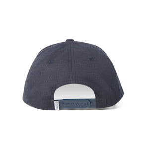 The dark blue Ringers Western Grover Baseball Cap is shown from the back, featuring an adjustable strap with snap buttons for size adjustment. The tag near the strap, displaying Ringers Western branding, is partially visible. The fabric appears smooth, and the cap boasts a simple design without any visible logos or embellishments.