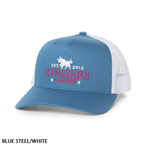The Ringers Western Western Star Trucker Cap features a blue front and brim, complemented by a white mesh back and an adjustable strap. The cap is embroidered with the text "EST. 2012 RINGERS WESTERN" in pink and white, accompanied by a white bull logo above the text. It is styled in "BLUE STEEL/WHITE," as indicated at the bottom left corner.