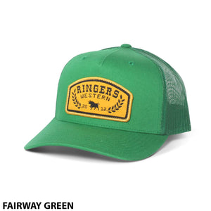 The Ringers Western Wheatbelt Trucker is a green cap with a mesh back and adjustable strap, featuring a yellow "Ringers Western" patch with laurel branches and two bulls. "FAIRWAY GREEN" appears below the hat.