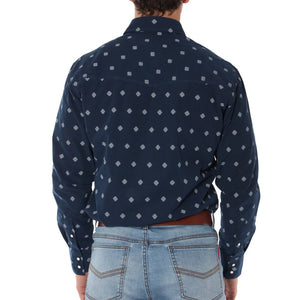 A person is standing with their back to the camera, wearing a dark navy blue Ringers Western Wyoming Shirt patterned with small white geometric shapes and light blue jeans with visible back pockets. The semi-fitted shirt, crafted from 100% cotton, has its sleeves buttoned at the wrists.