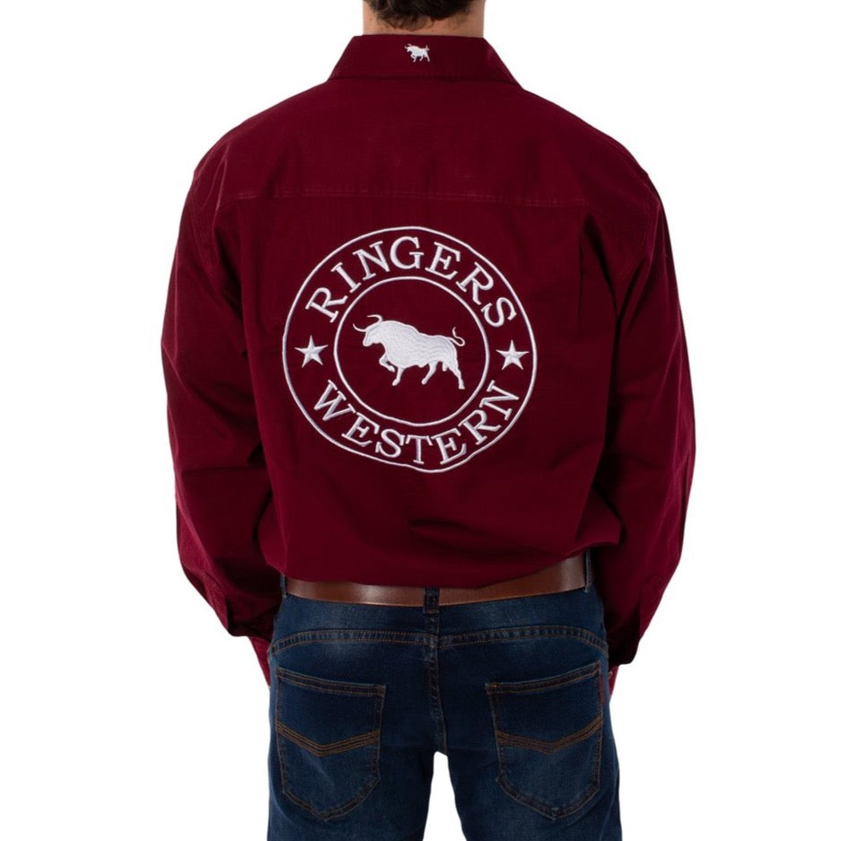 A person is wearing a Ringers Western Hawkeye Embroidered Shirt in maroon, featuring a white bull logo on the back. The 100% cotton shirt has long sleeves, a collar, and UPF50+ protection. They're also dressed in dark blue jeans.