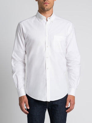 A man wearing an RM Williams Collins Shirt and dark blue jeans stands against a plain light grey background.