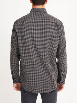 A man is seen from behind wearing the RM Williams Collins Shirt, a long-sleeved button-up with a small black and gray check pattern in soft brushed cotton, against a plain white background.