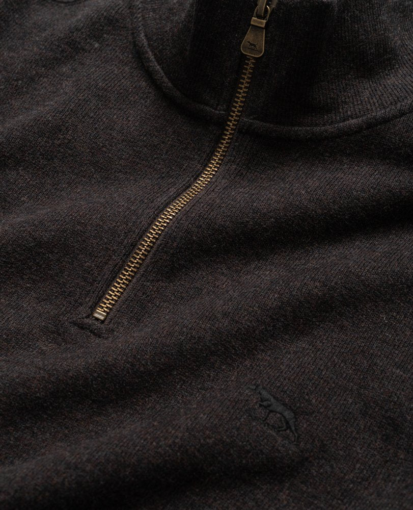Close-up image of the Rodd & Gunn Alton Ave Sweat, a dark brown, 100% cotton zip-up sweater with a high collar. This relaxed fit piece features a small embroidered emblem of a dog near the bottom of the contrasting bronze zipper. The fabric appears soft and textured.