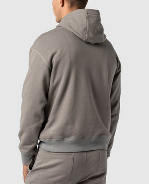 A person wearing the Rodd & Gunn Worser Bay Sweat hoodie and matching pants is seen from the back, featuring a Rodd & Gunn logo. The hoodie includes a hood and the fabric appears soft and comfortable. The image focuses on the upper half of the body, highlighting the back view and showcasing its soft fleece lining.