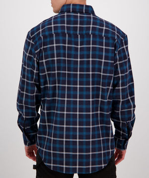 A person wearing a navy blue and white plaid long sleeve shirt from the Swanndri Egmont Flannelette Twin Pack is seen from the back. They have dark pants on, and the background is plain white.