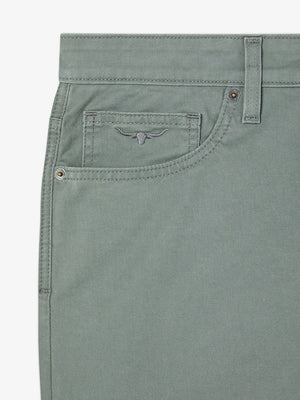 Close-up of a gray-green denim section featuring the waist, belt loops, button, and small front pocket. The stitched bull logo decorates the pocket with metal rivets at seams on a white background. Ideal for fans of RM Williams Nicholson Short quality.