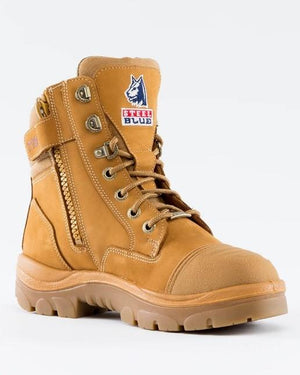 The Steel Blue Southern Cross Ladies Zip Scuff Boot in tan features a safety steel toe and a convenient side zipper. It boasts sturdy laces, reinforced toes, padded ankle support, and a rugged sole for excellent traction. The boot is adorned with a logo patch featuring a wolf and the words "Steel Blue" on the front.