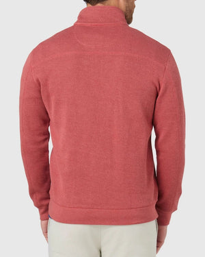 A man is shown from the back wearing the Blazer Heather Half Zip Sweat, a textured long-sleeve red top, paired with light-colored pants against a plain light background.