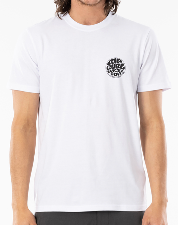 A person wearing the Rip Curl Wetsuit Icon Tee, which is a plain white, 100% cotton T-shirt with short sleeves. There is a round black and white Rip Curl print on the left chest area featuring text. The person's face is not visible in the image.