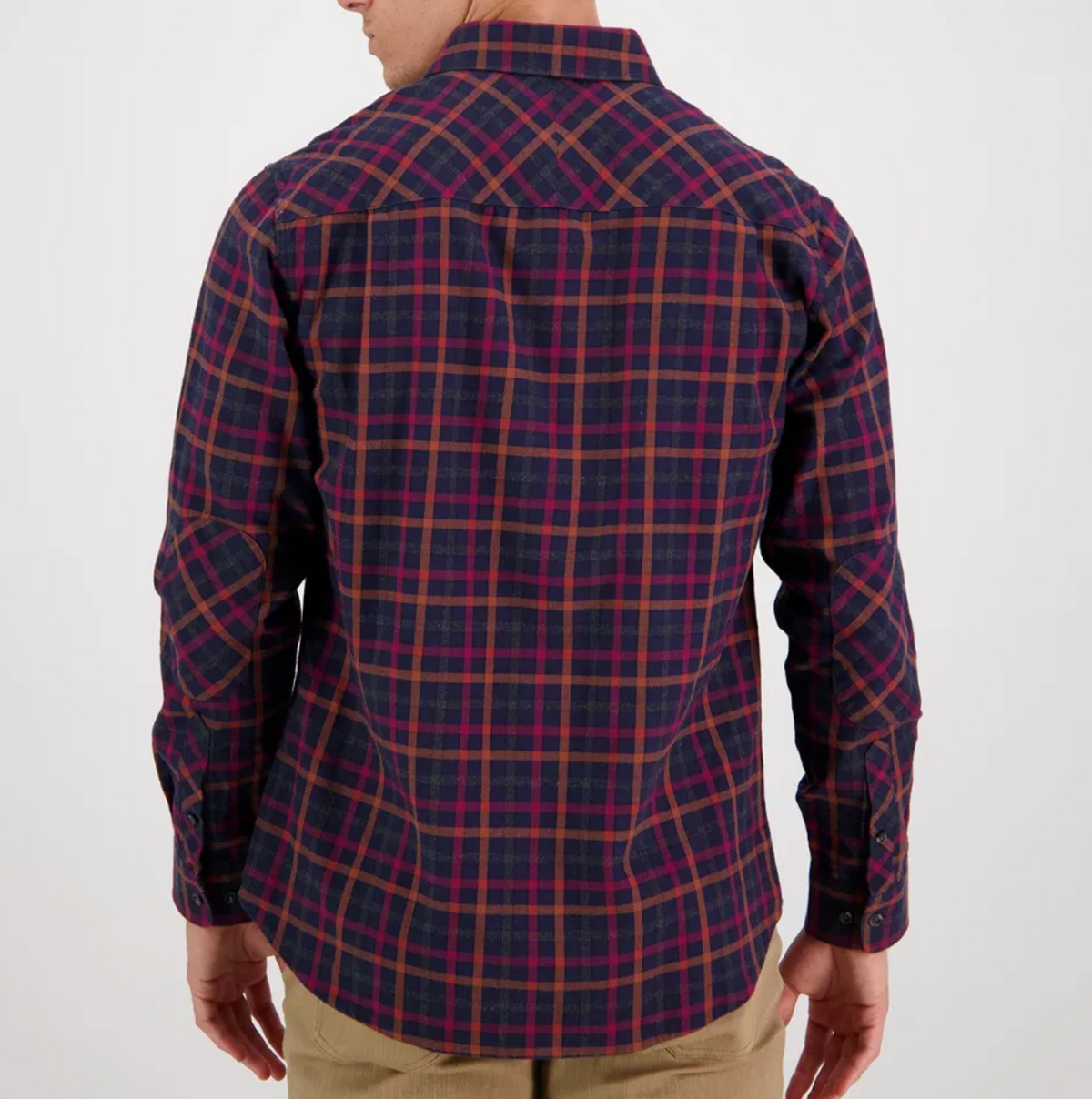 A person wearing a Swanndri Fernald Point Shirt, a long-sleeve, dark blue and red plaid shirt made from 100% cotton, faces away from the camera. The classic-fit shirt is paired with beige pants against a plain white background.