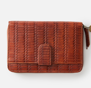 The Rip Curl Hermosa RFID Leather Wallet features a textured woven pattern, brown finish, secure snap closure, and a right-side zipper. It combines style with RFID protection against digital theft, highlighted on a plain white backdrop.