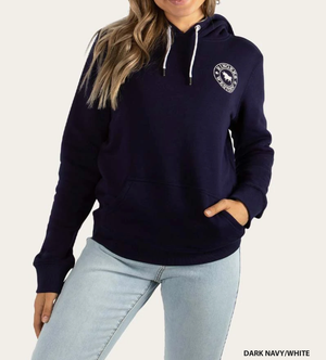 A person with long hair is wearing a casual, comfortable Ringers Western Womens Signature Bull Hoodie in dark navy, which features a small circular logo on the chest and white drawstrings. They are also wearing light blue jeans and have one hand in the hoodie pocket. The text "DARK NAVY/WHITE" is at the bottom-right corner of the hoodie.