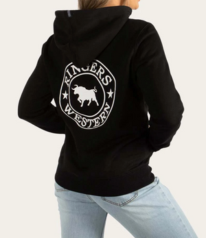 A person is wearing a Ringers Western Womens Signature Bull Hoodie in black, adorned with a white bull and stars logo on the back. They pair it with light blue jeans, enhancing their relaxed and casual look as they face away from the camera.