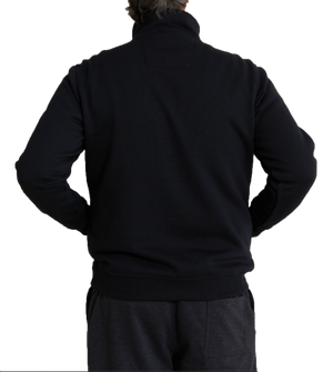 A person with gray hair is seen from behind wearing a Breakaway Hils Snowy Mt Fleece Half Zip with a rib knit collar and dark-colored pants. The individual has their hands on their hips, adding a casual stance against the plain white background.