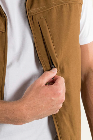 Someone in a white shirt is zipping up the Ringers Western Macquarie Canvas Vest, with a focus on their hand gripping the zipper of this cozy, sherpa-lined layer.