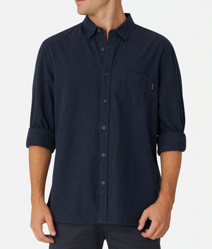 A person wearing Industrie The Taylor Shirt in dark blue with long sleeves rolled up to the elbows. The comfortable and casual shirt features a chest pocket on the left side, and the person is standing against a plain white background. The face and background details are not visible.