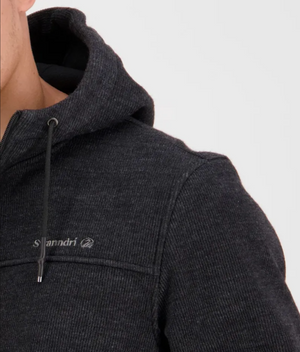 A close-up of someone wearing a Swanndri Rifleman Wool Blend Hoodie showcases its dark, water-resistant fabric with a small chest logo. The hoodie, featuring a zipper and drawstring, balances functionality and style; only part of their face is visible, highlighting the hoodie's design.