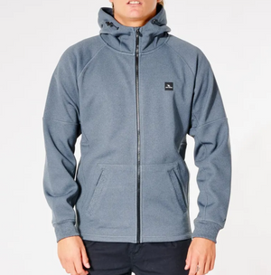 A person wearing the Rip Curl Anti Series Storm Zip Thru, a gray long-sleeve zip-up hoodie with a hood and two front pockets. The hoodie features Durable Water Resistant protection and a small black rectangular logo on the left chest. The person is standing against a plain white background.