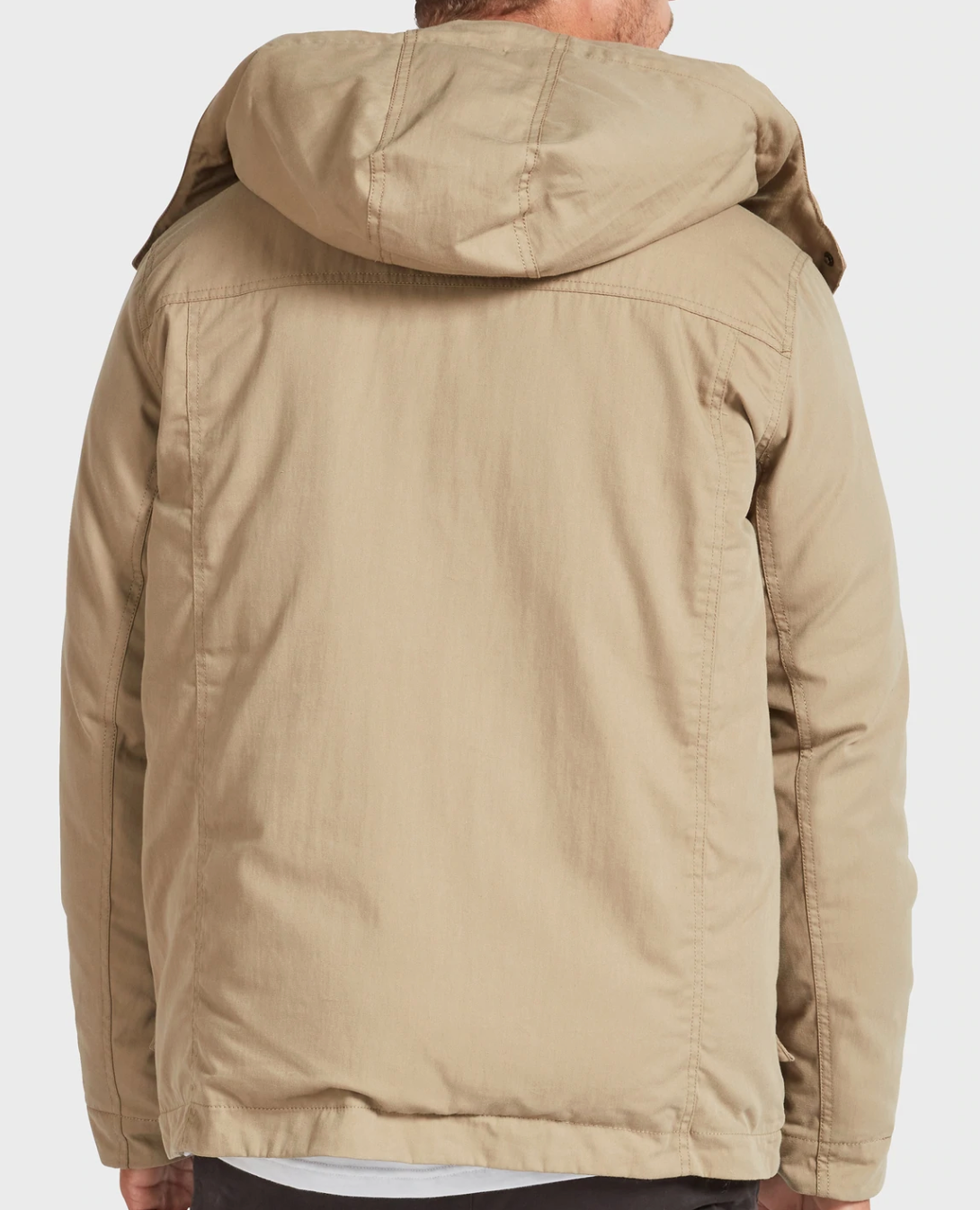 A person is seen from the back wearing the Academy Brand Miller Jacket, a stylish light brown padded jacket with visible seams and a hood up, covering the waist and partially obscuring the neck and head.