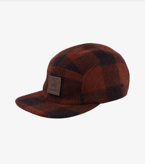 The Swanndri Wentworth Valley Cap is a brown and black plaid cap with a flat brim, adorned with a leather patch featuring the Swanndri logo on the front. Displayed elegantly on a white background.