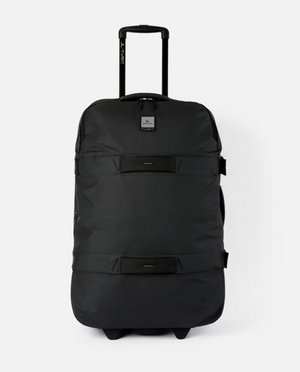 The Rip Curl F-Light Global 110L Midnight Travel Bag is a large black rolling duffel with a telescopic handle and two wheels. It has a rectangular logo patch on the front, durable fabric, a smooth surface, and two horizontal straps.