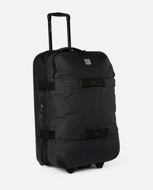 The sleek Rip Curl F-Light Global 110L Midnight Travel Bag, features a retractable handle, minimal straps, small front logo, and stands upright against a plain white background.