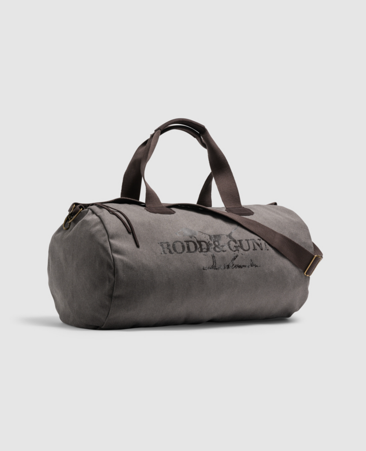 The Rodd & Gunn Double Barrel Duffle Bag features gray cotton canvas with dark handles and a shoulder strap, embroidered with "Rodd & Gunn" on the side. It is displayed against a plain, light background.
