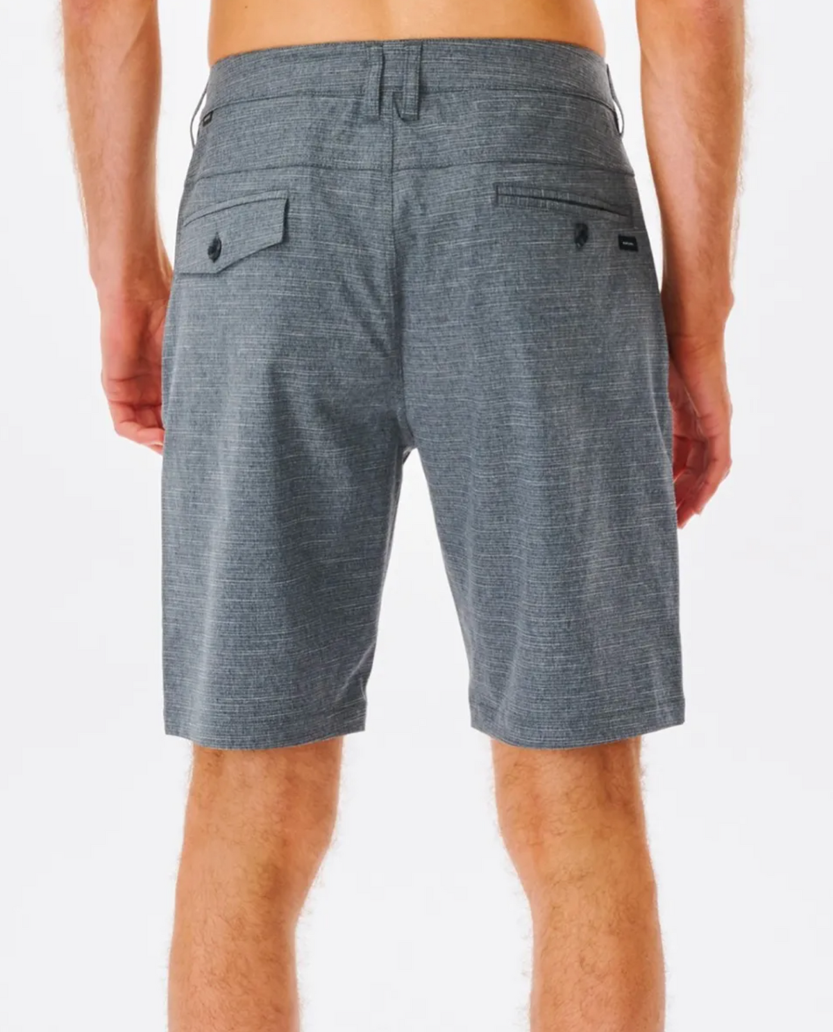 A person is seen from the back, wearing Rip Curl Boardwalk Epic Mix Shorts in gray, made of stretch recycled polyester for quick-dry comfort. The shorts have two hip pockets with button details. The plain white background accentuates the person's relaxed pose with hands by their sides.